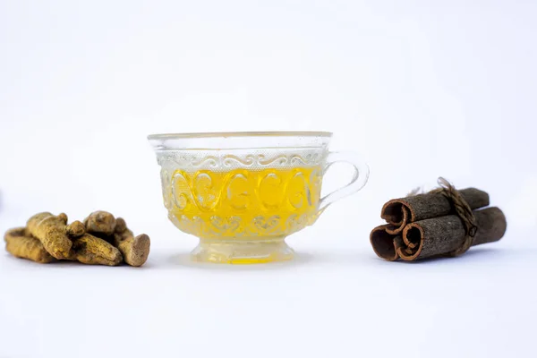 Popular turmeric tea isolated on white with its entire ingredients which are turmeric powder and raw, honey and cinnamon sticks.Used for detoxifying body.Isolated on white.