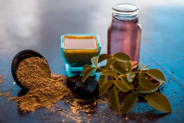 Face pack of devil's dung powder on wooden surface i.e. Hing powder well mixed with sandal wood powder or chandan and rose water.Used for the treatment for instant glow.