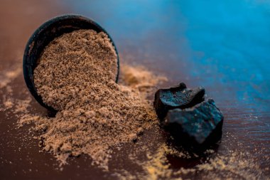 Ham organik menting veya şeytan gübresi veya Asafoetida siyah renkli kil kase ve bazı nane yaprakları veya mentha yaprakları onun tozu ile birlikte ahşap yüzeyüzerinde.