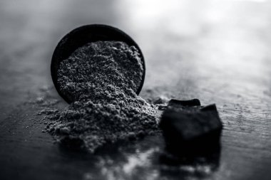 Ham organik menting veya şeytan gübresi veya Asafoetida siyah renkli kil kase ve bazı nane yaprakları veya mentha yaprakları onun tozu ile birlikte ahşap yüzeyüzerinde.