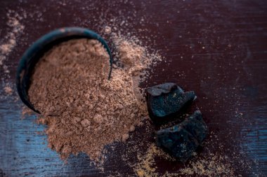 Ham organik menting veya şeytan gübresi veya Asafoetida siyah renkli kil kase ve bazı nane yaprakları veya mentha yaprakları onun tozu ile birlikte ahşap yüzeyüzerinde.