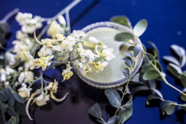 Ayurveda bitki Drumstick cam bir kase içinde onun hamur ile birlikte ahşap yüzeyüzerinde bazı yaprakları ile birlikte çiçekler.