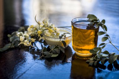 Bir bardak içinde çıkarılan su veya tentür ile birlikte ahşap yüzeyüzerinde baget demet.