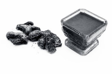 Çiğ kurutulmuş zencefil ve macunu veya tentürü beyaz üzerine izole edilmiş cam bir kapta.