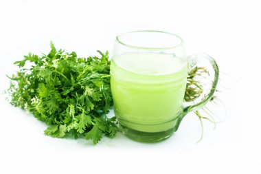 Taze maydanoz yaprakları ile beyaz izole şeffaf bir cam taze maydanoz suyu veya kişniş suyu.