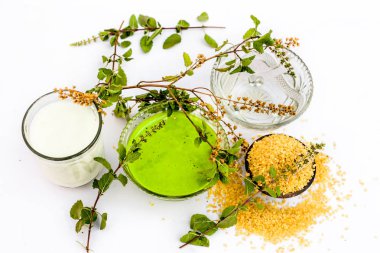 Beyaz yani yulaf ezmesi izole tulsi yüz paketi veya yüz maskesi iyi tans veya güneş yanıkları için kullanılan süt ve su ile tulsi veya kutsal fesleğen ile karıştırılır.