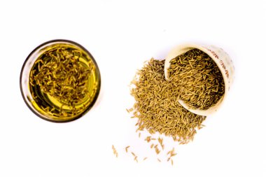 Beyaz arka plan üzerinde izole kase ham organik kimyon ile cam bitkisel detoksifiye içecek Jeera su 