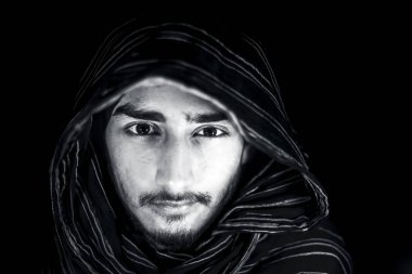 Siyah beyaz renkli bir adamın yüzünde ki öfkeyi ifade eden ve yüzünde siyah renkli bez giyen siyah renkli bir portre fotoğrafı.