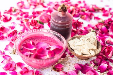 Gül suyu yüz paketi iyi bir cam kase ve yüzeyde mevcut tüm malzemeyi mulpani mitti veya dolgun toprak ile karışık gül yaprakları ile izole, Exfoliation için kullanılır.