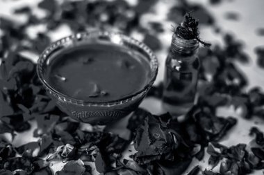 Bazı uçucu yağ veya yüzeye yayılmış bazı gül yaprakları ile birlikte bir cam şişede gül konsantrasyonu ile bir cam kase Gül Reçeli.