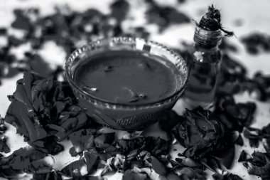 Bazı uçucu yağ veya yüzeye yayılmış bazı gül yaprakları ile birlikte bir cam şişede gül konsantrasyonu ile bir cam kase Gül Reçeli.