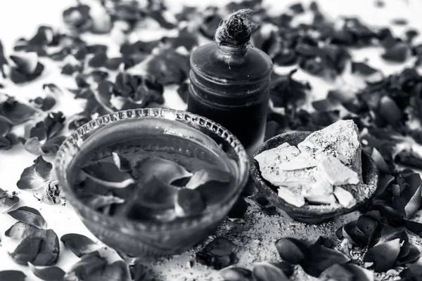 Gül suyu yüz paketi iyi bir cam kase ve yüzeyde mevcut tüm malzemeyi mulpani mitti veya dolgun toprak ile karışık gül yaprakları ile izole, Exfoliation için kullanılır.