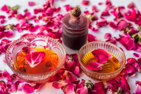 Rose water face pack isolated with essential oil of rose well mixed with honey in a glass bowl and entire raw ingredients present on the surface used for skin brightening.