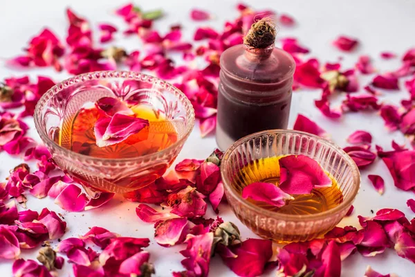 Rose water face pack isolated with essential oil of rose well mixed with honey in a glass bowl and entire raw ingredients present on the surface used for skin brightening.