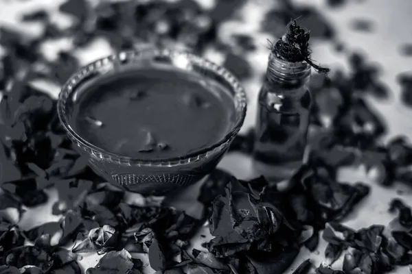 Bazı uçucu yağ veya yüzeye yayılmış bazı gül yaprakları ile birlikte bir cam şişede gül konsantrasyonu ile bir cam kase Gül Reçeli.