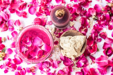 Gül suyu yüz paketi iyi bir cam kase ve yüzeyde mevcut tüm malzemeyi mulpani mitti veya dolgun toprak ile karışık gül yaprakları ile izole, Exfoliation için kullanılır.