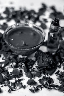 Bazı uçucu yağ veya yüzeye yayılmış bazı gül yaprakları ile birlikte bir cam şişede gül konsantrasyonu ile bir cam kase Gül Reçeli.