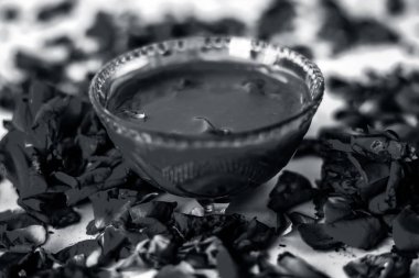 Bazı uçucu yağ veya yüzeye yayılmış bazı gül yaprakları ile birlikte bir cam şişede gül konsantrasyonu ile bir cam kase Gül Reçeli.