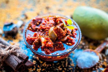 Bir cam kase içinde mango Popüler Hint & Asya turşusu yani aam ka achar bir cam kase veya keri ka achar siyah renkli parlak yüzey üzerinde baharat ve mango dahil olmak üzere tüm ham maddeler ile.