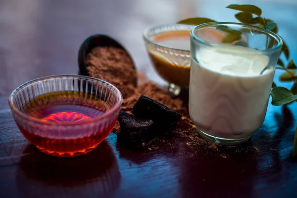 Face mask of devil's dung powder on wooden surface i.e. Hing powder well mixed with honey and milk.Used for anti-dryness along with entire raw ingredients present on the surface.