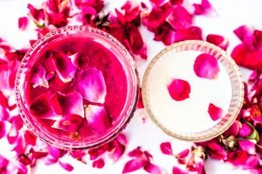 Gül yaprakları ve süt yüz paketi bazı gül yaprakları ve süt ile birlikte beyaz izole. Anlık parıltıiçin kullanılır.