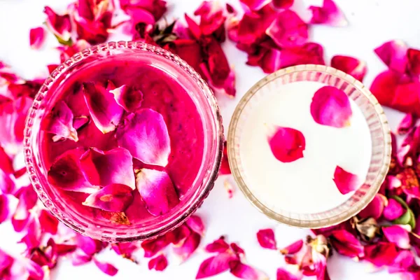 Gül yaprakları ve süt yüz paketi bazı gül yaprakları ve süt ile birlikte beyaz izole. Anlık parıltıiçin kullanılır.