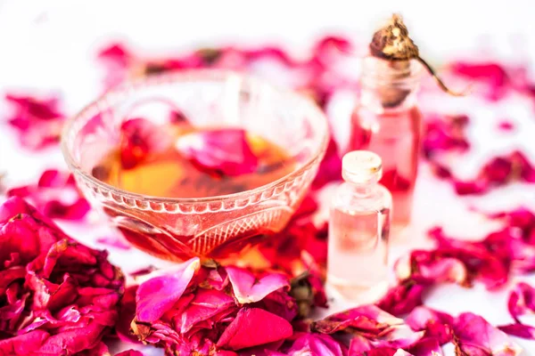 Rose face pack for dry skin isolated on white i.e. Rose petals well mixed with rose oil and glycerin in a glass bowl and entire raw ingredients present.