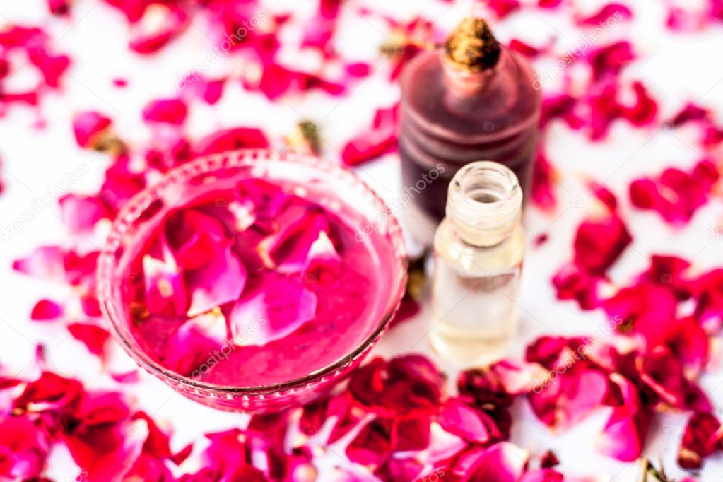 Rose face pack for dry skin isolated on white i.e. Rose petals well mixed with rose oil and glycerin in a glass bowl and entire raw ingredients present.