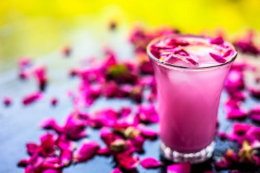 Ahşap yüzey üzerinde popüler Hint & Asya Yaz içki yani Gulab falooda veya gulab ka şerbat siyah renkli parlak yüzey üzerinde bazı gül yaprakları ile.