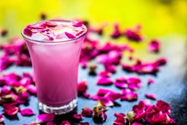Ahşap yüzey üzerinde popüler Hint & Asya Yaz içki yani Gulab falooda veya gulab ka şerbat siyah renkli parlak yüzey üzerinde bazı gül yaprakları ile.