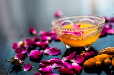 Tüm ham maddeler ile birlikte bir cam kase içinde çiğ süt, zerdeçal veya haldi ve badam oluşan siyah parlak yüzeyüzerinde Süt yüz paketi.