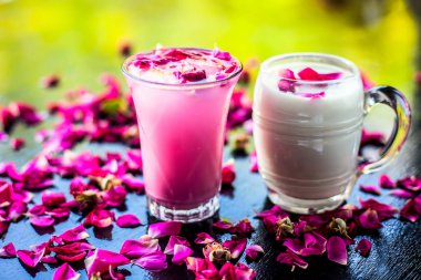 Ahşap yüzey üzerinde popüler Hint & Asya Yaz içki yani Gulab falooda veya gulab ka şerbat siyah renkli parlak yüzey üzerinde bazı gül yaprakları ile.