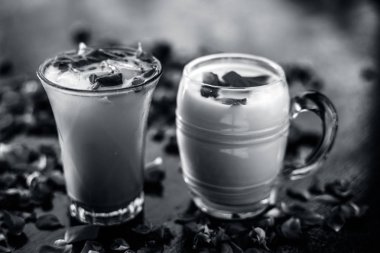 Ahşap yüzey üzerinde popüler Hint & Asya Yaz içki yani Gulab falooda veya gulab ka şerbat siyah renkli parlak yüzey üzerinde bazı gül yaprakları ile.