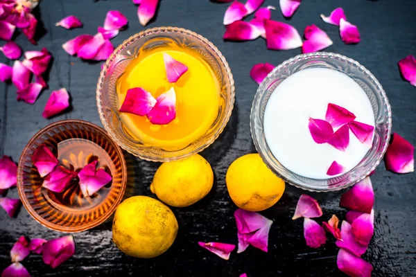 Milk face pack in a glass bowl used for brighter skin on wooden surface consisting of raw milk,honey and lemon juice.