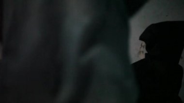 Dolly, yeşil tişört giyen ve yüzünü kaplayan siyah giysili diğer adama doğru ilerleyen bir adamın fotoğrafını çekti..