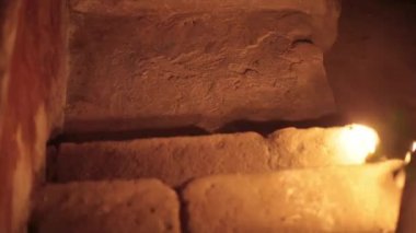 Ürkütücü bir yerde merdivenlerden çıkan bir erkeğin silueti mum ve fener yakıyor..