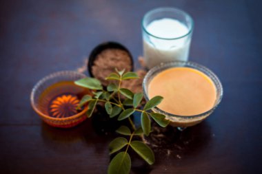 Ahşap yüzeyde kuruluk önleyici yüz paketi yani bir kapta bal ve süt le karıştırılan hing tozu ve yüzeyde bulunan tüm ham maddeler.