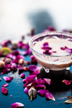 Sapodilla hamuru iyi ellerde şişkinlik için ahşap yüzeyinde bir cam kase çiğ süt ile karışık.