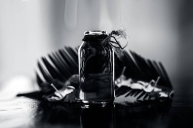 Biberiye konsantrasyonu veya özü, çiçekleri ve bazı yaprakları ile birlikte ahşap yüzeyüzerinde bir cam şişe.