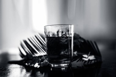 Biberiye çiçekleri ve yaprakları ile birlikte ahşap yüzeyüzerinde bir bardak biberiye çiçek ayıklanmış tentür veya çıkarma.