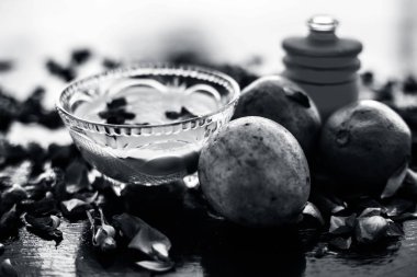 Sapodilla veya chikoo iyi içinde gül suyu kullanarak sandal ağacı ile karışık oluşan ahşap yüzey üzerinde yanaklar için yüz paketi.