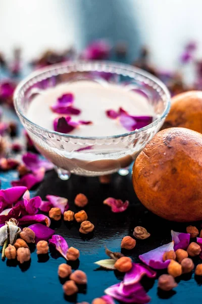 Sapodilla hamuru iyi ellerde şişkinlik için ahşap yüzeyinde bir cam kase çiğ süt ile karışık.