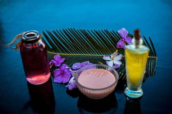 Ahşap yüzey üzerinde uzun kalın tüyler için saç tedavisi yani biberiye uçucu yağ iyi bir cam kase ve bazı biberiye çiçekleri de zeytinyağı ile karıştırılır.