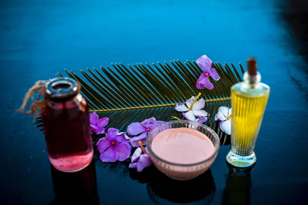 Ahşap yüzey üzerinde uzun kalın tüyler için saç tedavisi yani biberiye uçucu yağ iyi bir cam kase ve bazı biberiye çiçekleri de zeytinyağı ile karıştırılır.