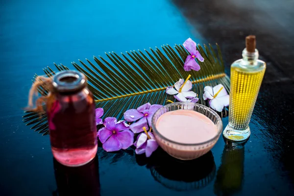 Ahşap yüzey üzerinde uzun kalın tüyler için saç tedavisi yani biberiye uçucu yağ iyi bir cam kase ve bazı biberiye çiçekleri de zeytinyağı ile karıştırılır.