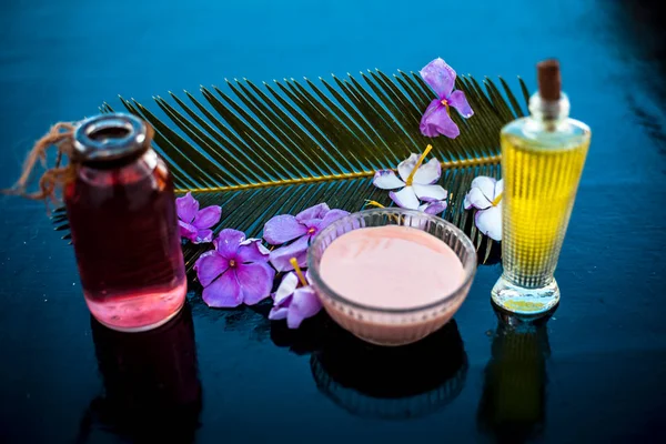 Ahşap yüzey üzerinde uzun kalın tüyler için saç tedavisi yani biberiye uçucu yağ iyi bir cam kase ve bazı biberiye çiçekleri de zeytinyağı ile karıştırılır.