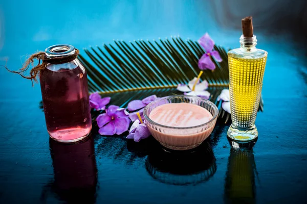 Ahşap yüzey üzerinde uzun kalın tüyler için saç tedavisi yani biberiye uçucu yağ iyi bir cam kase ve bazı biberiye çiçekleri de zeytinyağı ile karıştırılır.