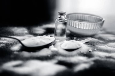 Yüz maskesi veya şeffaf bir cam şişede toz ve bazı hindistan cevizi yağı ile birlikte ahşap yüzeyüzerinde bir cam kase kabartma tozu yüz paketi. Döküntüler için kullanılır. Yatay atış.