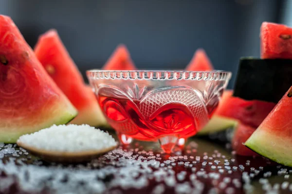 Best recipe ingredient to make homemade sugar scrub on wooden surface consisting of watermelon pulp well mixed with sugar in a glass bowl.