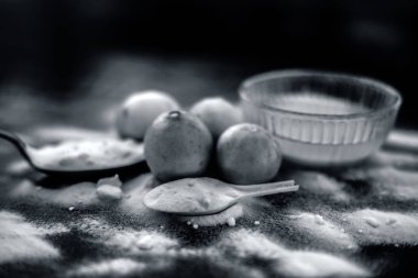 Kabartma tozu yüz maskesi ahşap yüzeyüzerinde cam bir kapta bazı kabartma tozu ile birlikte yüzeye serpilir ve limon da yüzeyde. Deriyi anında lekeler. Yatay atış.